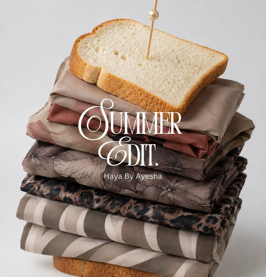 A stack of folded patterned fabric squares in neutral earth tones, topped with two slices of white bread and a toothpick with a bead, on a light gray background. White text across the center reads 'SUMMER EDIT' with smaller 'Haya By Ayesha' underneath.